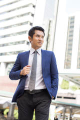 Young Hnadsome Businessman standing in City looking and ready for Work. Young Businessman have Confident for Work with Leader concept. Asian Businessman Thinking for Work in City.