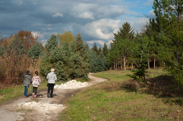 Obraz premium Mother with his daughters walking in the park. Cloudy weather in early autumn