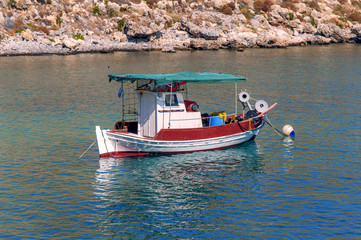 Fototapeta na wymiar White and red docked vintage wooden motor boat at sea