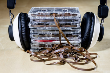 Cassette tape and headphones for listening to music. Old good music from the 80s. Wooden table.