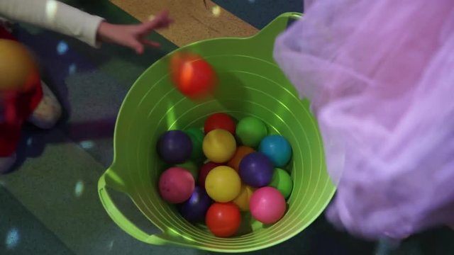 children throw colored balls in the basket