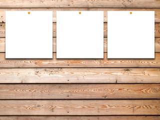 Three square blank frames with pins on brown wooden boards background