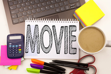 Word writing Movie in the office with laptop, marker, pen, stationery, coffee. Business concept for Entertainment Movie Film Workshop white background with copy space