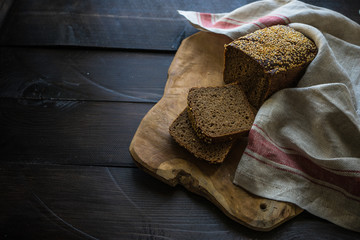 Homemade organic rye bread on cutting board with vintage towel