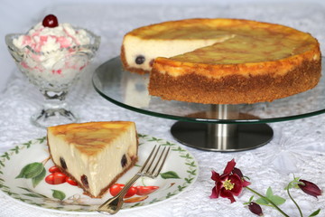 Käsekuchen mit Kirschen auf Tortenplatte mit Schlagsahne