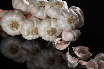 String of french pink garlic on old tin plate on black background