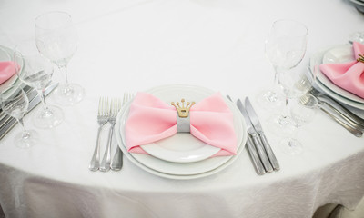 Festive table setting of the wedding table with crystal glasses and pink and white napkins