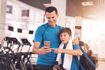 Obraz premium Dad and son in the same clothes in gym. Father and son lead a healthy lifestyle.