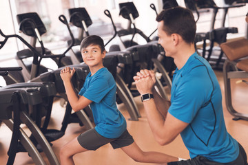 Fototapeta na wymiar Dad and son in the same clothes in gym. Father and son lead a healthy lifestyle.