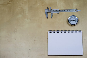 Materials, accessory and spare parts for hydraulics. Notes and measuring tools on the workshop table.