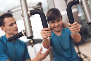 Fototapeta premium Dad and son in the same clothes in gym. Father and son lead a healthy lifestyle.