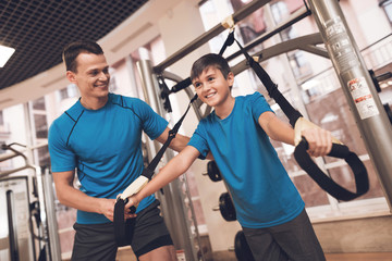 Fototapeta na wymiar Dad and son in the same clothes in gym. Father and son lead a healthy lifestyle.