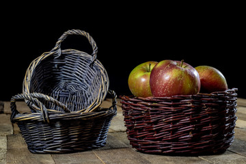 Tasty apples in basket on kitchen table. Autumn season. Wooden table.