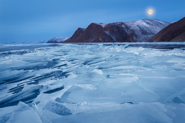 Full moon over frozen Baikal lake. Siberia.