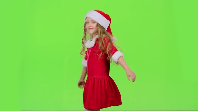 Child girl is spinning in her New Year's costume. Green screen