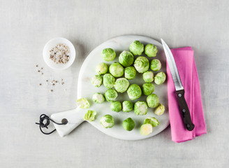 Brussels sprout on a white marble cutting board and knife. spices and food ingredients. cooking healthy food