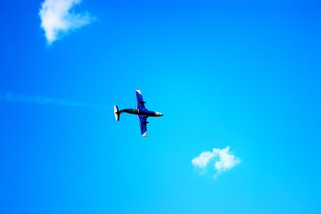 Airplane flying in the blue sky among clouds