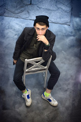 Top view of a young fashion man sitting on chair at grunge