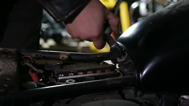 Mechanics hand unscrewes the nut to unlock fuel tank