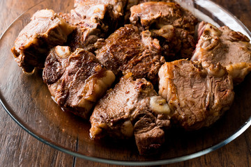 Lamb Meats in glass bowl on dark wooden surface.
