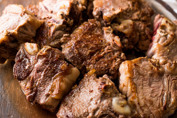 Lamb Meats in glass bowl on dark wooden surface.