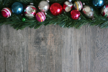 Festive Colorful Holiday Christmas Ornament Border Over Garland and Wood Background