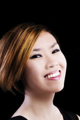 Fototapeta premium Asian American Woman Smiling Portrait Against Dark Background