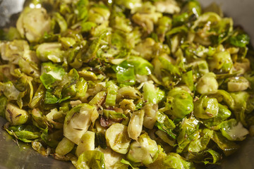 Sliced, pan fried brussels sprouts in a steel wok