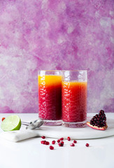 Freshly squeezed pineapple and pomegranate juices on a marble board on a table. morning charge. healthy eating