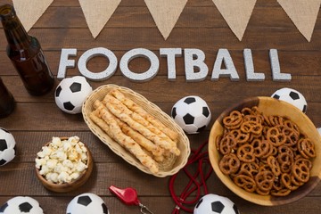 Football text and snacks on wooden table