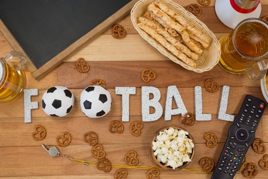 Remote control, slate, snacks, drinks and football word arranged