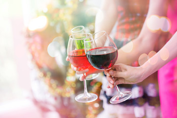 Friends celebrating Christmas or New Year eve and hands hold a glass of champagne