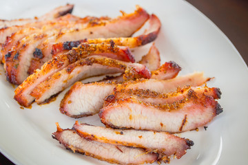 Grilled pork cut into pieces on a plate.