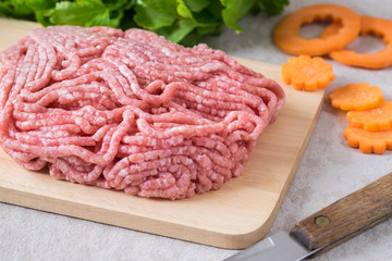 Raw minced pork on wooden chopping board