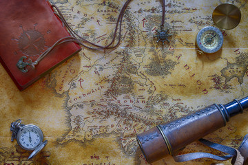 Ancient map (possibly pirate or treasure or middle-earth) with adventure attributes stuff (compass, notepad, telescope and pocket watch) around the perimeter