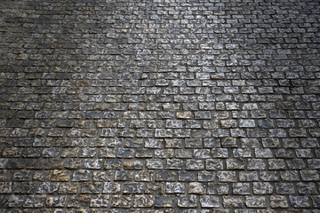 old cobblestone street road surface at night backlit background texture photo