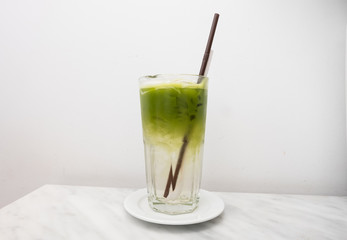 ice green tea drink with coconut in glass on white background.