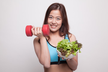 Beautiful Asian healthy girl with dumbbell and salad.