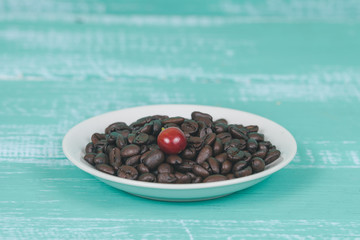 fresh coffee beans on dry coffee beans in dish.