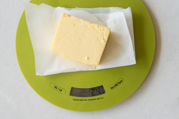 Slice of butter on digital kitchen scale