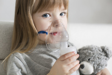 Little girl making inhalation with nebulizer at home. child asthma inhaler inhalation nebulizer steam sick cough concept - obrazy, fototapety, plakaty