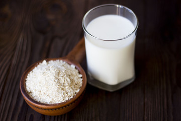 porridge in a clay pot and a glass of milk on a wooden table