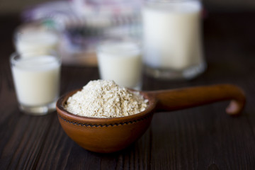 porridge in a clay pot and a glass of milk on a wooden table