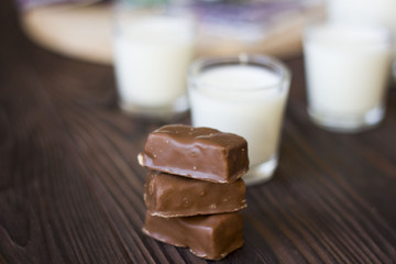 chocolates and glasses of milk on a wooden table