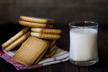 cookies and glasses of milk on a dark wooden table