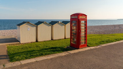 Beach huts and phone booth near trhe pebble beach, Budleigh Salterton, Jurassic Coast, Devon, UK