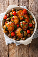 Pieces of chicken fried with chestnuts and tomatoes close-up in a bowl. Vertical top view