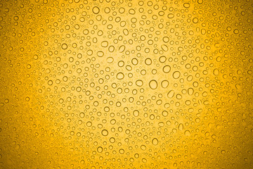 Water drops on yellow glass, Rain droplets on glass background.