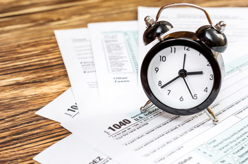 Tax forms with clock on the table. Business and tax concept.