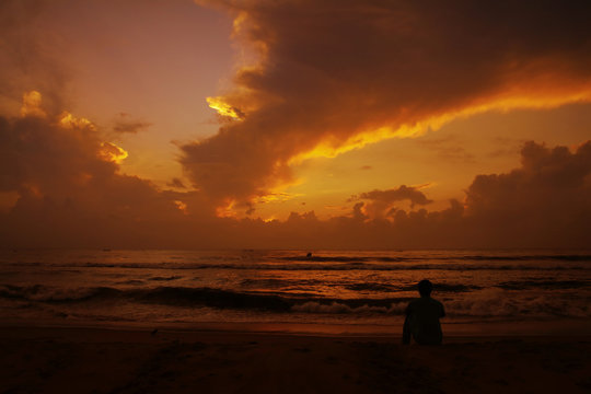 Thoughtful young man sitting and watching the sunset. © V.R.Murralinath
